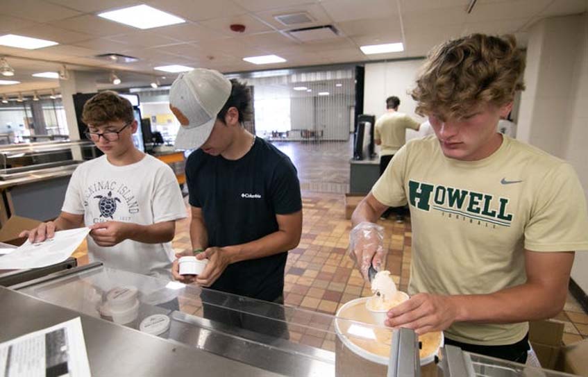 Howell High School varsity football players, from left, Ethan Schultz, Ben Brown and Jonathan Sexton, all juniors this year, pack and label melon ice cream on Wednesday, Aug. 10, 2022, for the Howell Melon Festival.